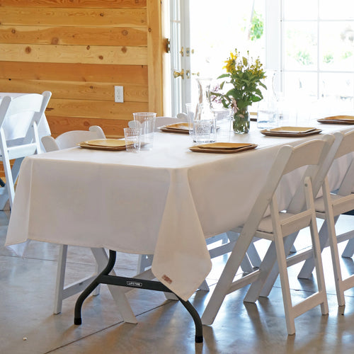 White, mid-length tablecloths for rectangle tables.